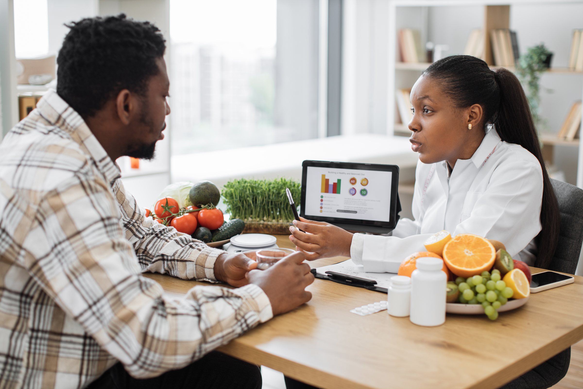 A man discussing a personalised health plan with a nutritionist